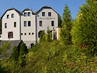 Bílá fasáda hotelu ADLER v letním období